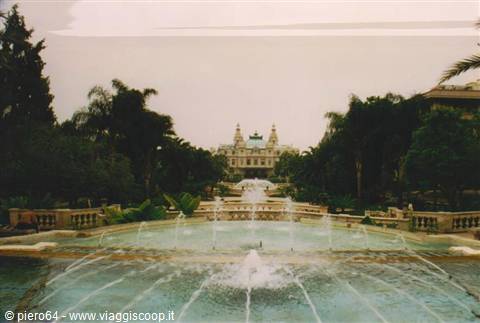 Fountains in the foreground in front of the Monte Carlo Casino among palms