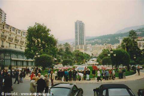 Tourists on the square by flower beds in front of Monte Carlo Casino
