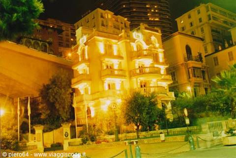 Art nouveau building lit up at night among Monte Carlo towers