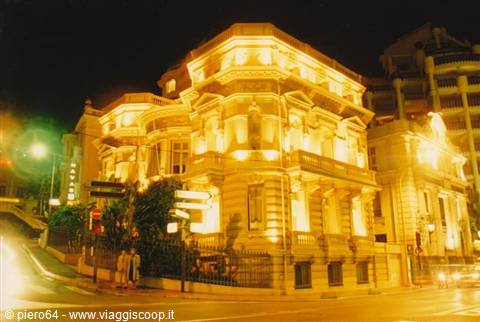 Stone palace glowing golden at night, street corner with signs