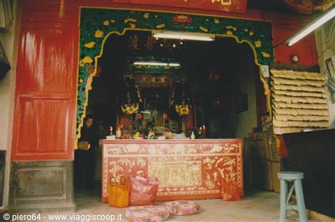 Red and gold Chinese temple altar with incense burning at entrance
