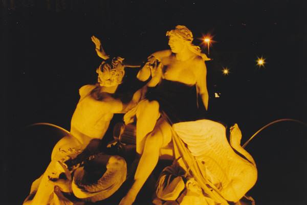 Marble statue of Leda and the swan lit by golden night lights