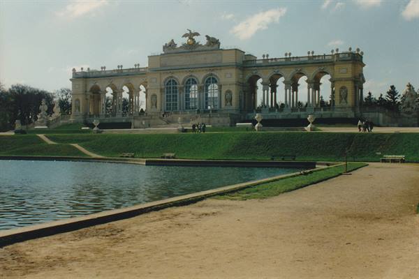 The Gloriette at Schönbrunn with stone arches, pond and green lawn in front