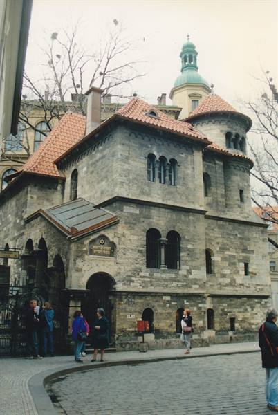 Tourists outside the Klausen Synagogue, grey stone and red roofs, Prague
