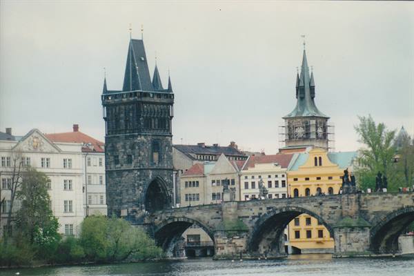 Gothic stone tower and arches of Charles Bridge over the Vltava, Prague
