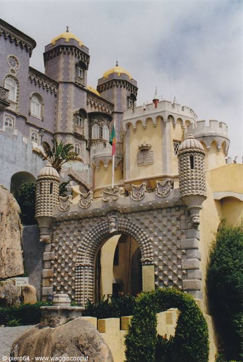 Pena Palace in Sintra: yellow battlemented towers, stone arches, flag