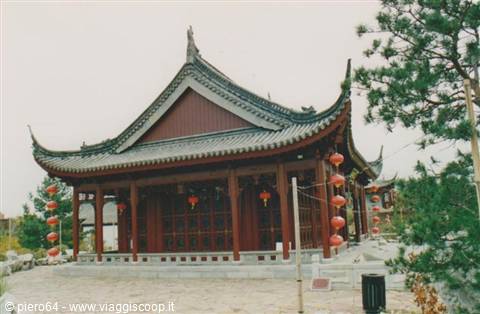 Chinese wooden pavilion with curved tiled roof and red lanterns