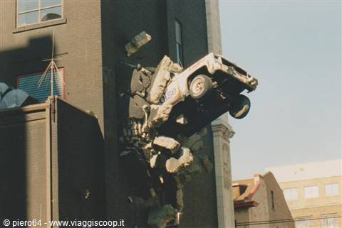 Land Rover truck stuck vertically into a dark brick building facade
