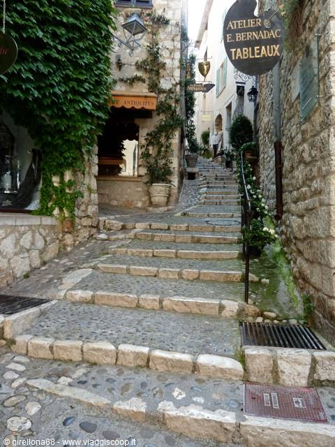 Stone steps climbing between old houses and ivy, Atelier E. Bernadac sign