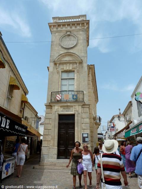 Tourists walk past the pale stone museum building in Saint-Martin-de-Ré