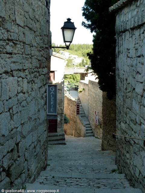 Narrow stone alley with steps and lantern, Gallerie sign between old walls