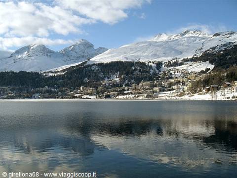 Frozen lake in front of snowy St. Moritz village beneath white peaks
