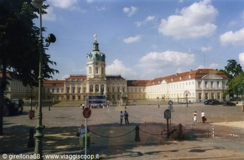 Charlottenburg Palace in Berlin, baroque facade under cloudy sky, visitors on the square