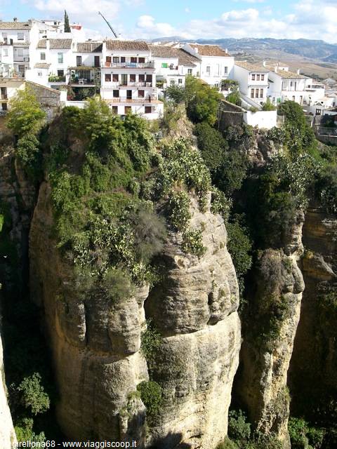 White houses above the Tajo gorge in Ronda, rocks and greenery