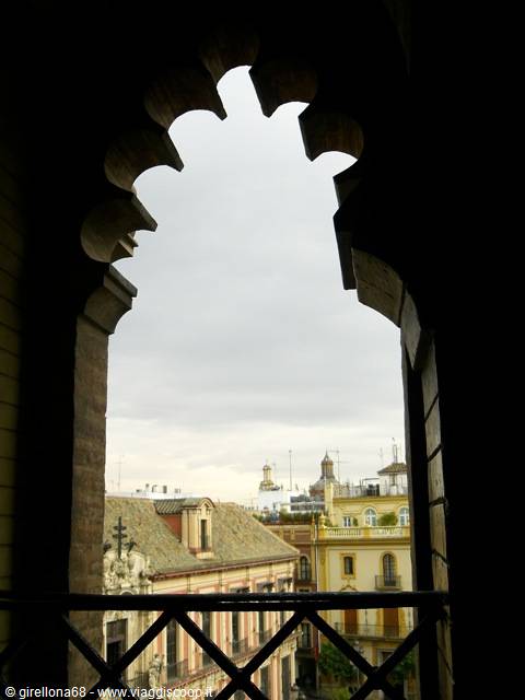 Moorish stone arch of the Giralda overlooking Seville rooftops