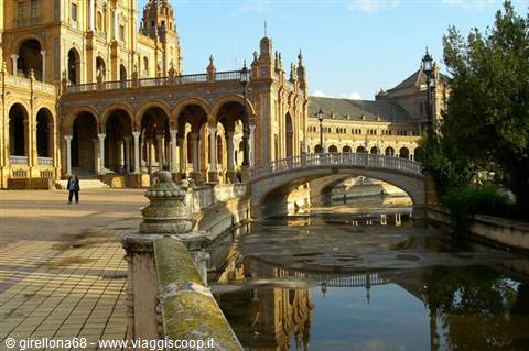 Plaza de España in Seville, brick bridge over the canal reflecting in water