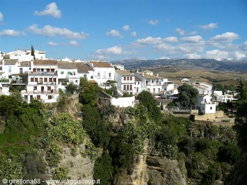 Whitewashed houses on the cliff in Ronda, blue sky with clouds