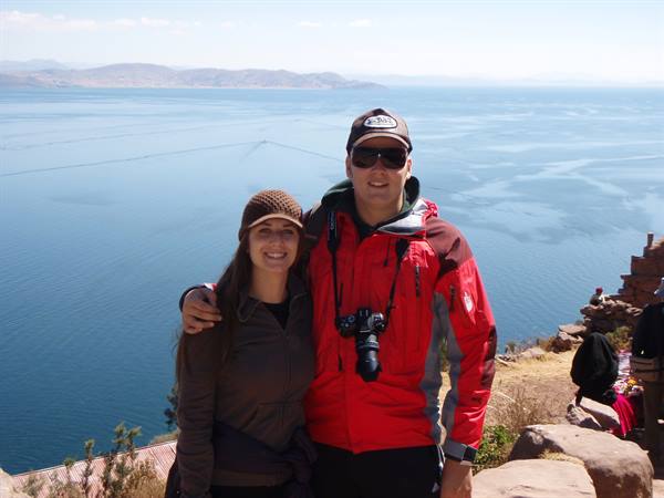 Couple with camera standing before Lake Titicaca, Taquile island
