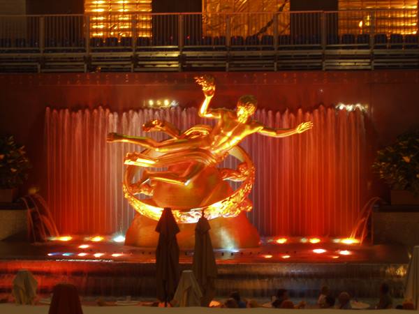 Golden Prometheus statue in front of illuminated waterfalls at Rockefeller Center