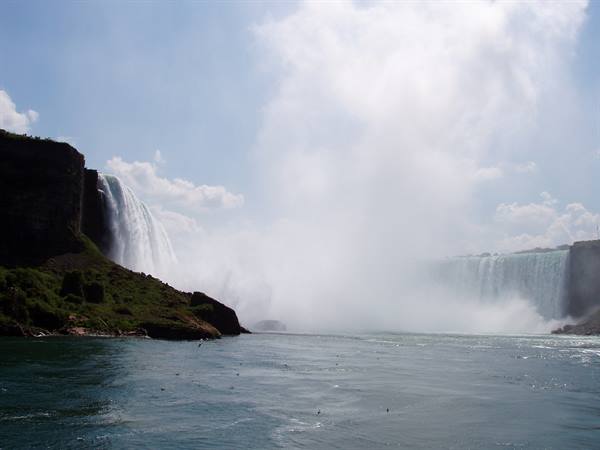 Niagara Falls raising white mist over the dark green water