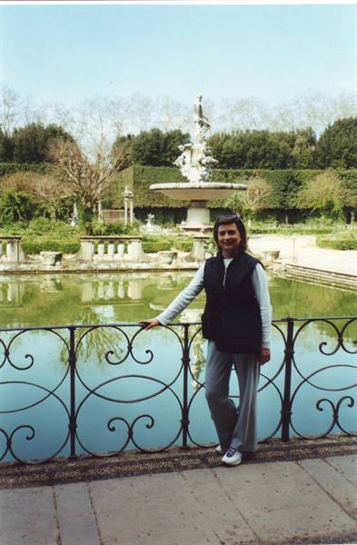 Woman leaning on the iron railing in front of the fountain in Boboli Gardens, Florence