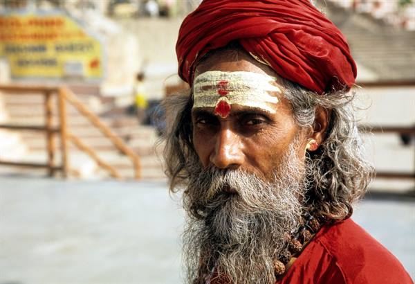 Sadhu in red turban with forehead tilaka, grey beard, on the ghats