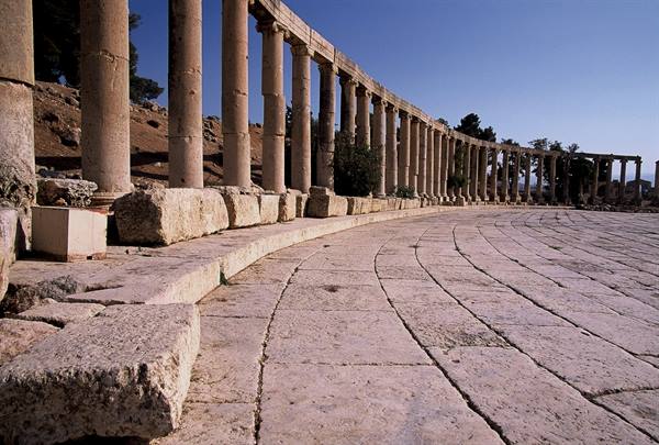 Curved stone colonnade on the oval plaza of Jerash, sunlight