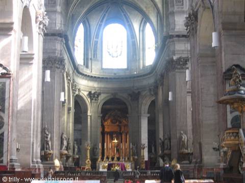 Baroque stone church nave, light from windows above the gilded altar