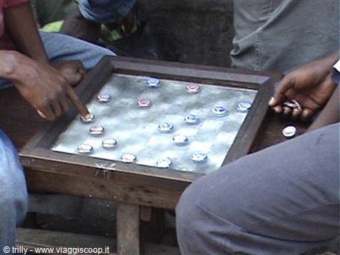 Men playing checkers on wooden board with bottle caps