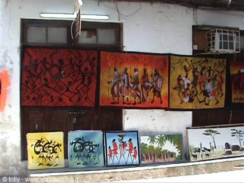 Paintings with tribal figures hanging on a white facade