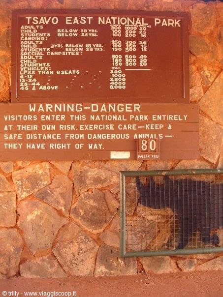 Wooden sign with fees and danger warning, Tsavo East National Park