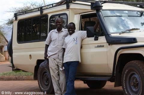 Two safari guides posing beside a white 4x4 Land Cruiser