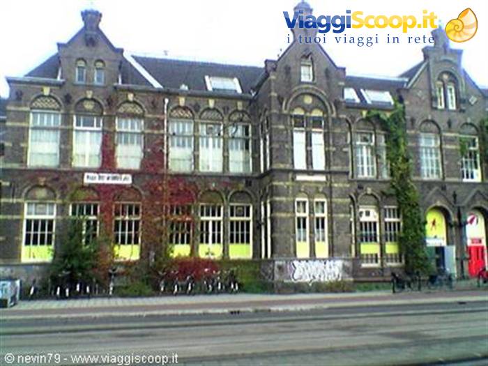 Brick facade of an old Amsterdam building, bicycles parked beneath the windows