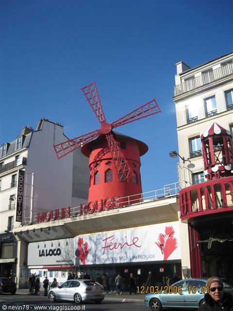 The red windmill of the Moulin Rouge in Paris under blue sky