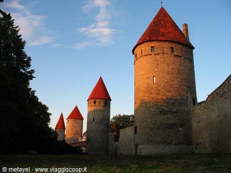 Medieval stone towers with red conical roofs in Tallinn, golden light