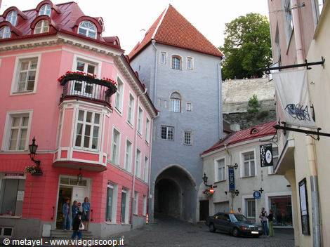 Medieval arched gate tower among colorful houses in Tallinn