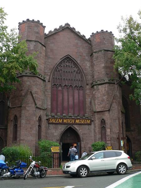 Salem Witch Museum, dark Gothic stone facade with tourists at entrance and parked cars