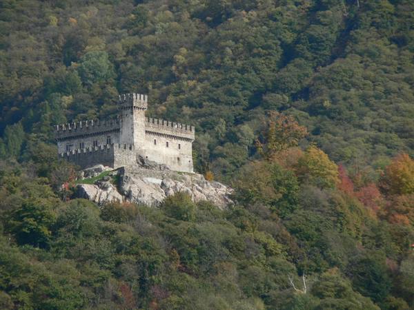 Sasso Corbaro castle on rocky hill amid autumn forest, Bellinzona