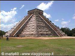 Kukulkan pyramid at Chichen Itza, tourists on the staircase under sunny sky