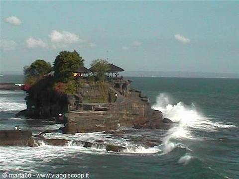 Tanah Lot temple on volcanic rock, waves crashing around it