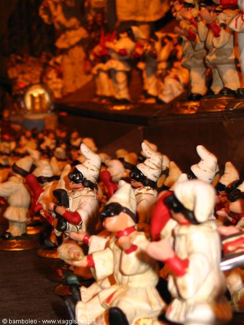 Terracotta Pulcinella figurines displayed under warm light
