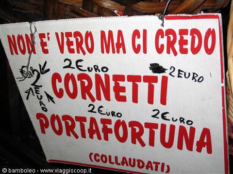 Hand-painted sign advertising lucky croissants for two euros, red letters on white