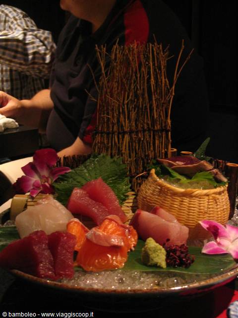 Tuna and salmon sashimi on bamboo leaf with wasabi and orchids