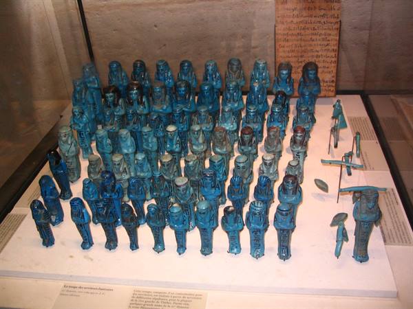 Turquoise faience shabti figurines displayed in a museum glass case