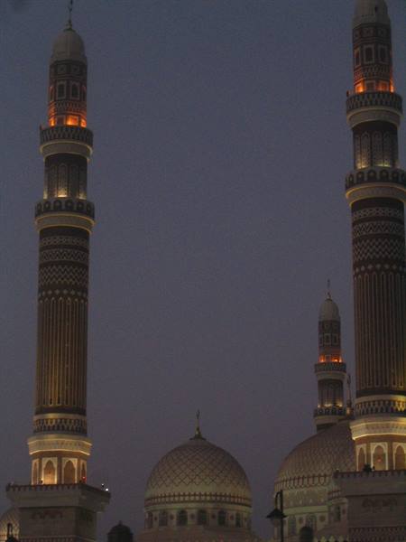 Illuminated decorated minarets and domes of the al-Saleh Mosque at dusk
