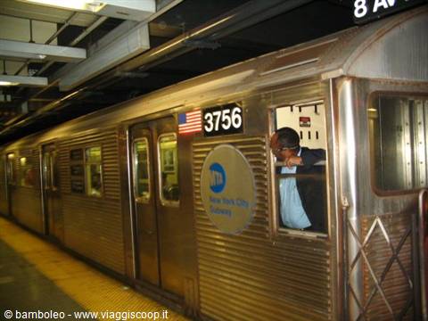 New York City subway train waiting at the station, conductor at the window