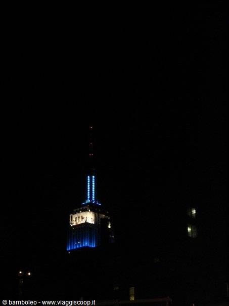 Empire State Building skyscraper lit up in blue at night