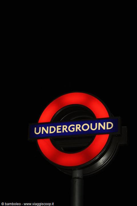 Illuminated red Underground roundabout sign glowing in the dark London night