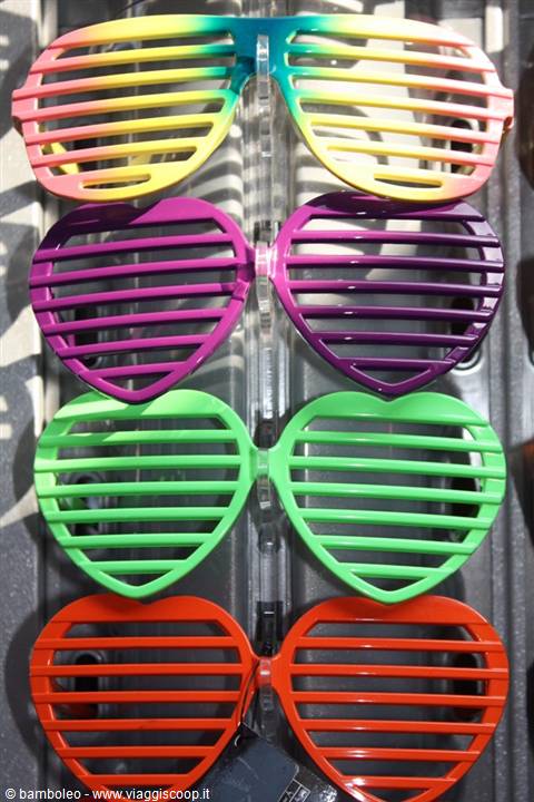 Colorful shutter shades glasses hanging on display, glossy plastic in natural light