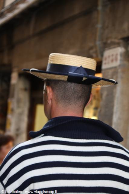 Gondolier wearing straw hat and striped shirt in Venice